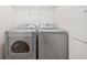 Laundry room with modern silver appliances, including a front load washer and dryer at 5965 Ellington Cv, Cumming, GA 30040