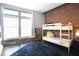 Cozy bedroom with bunkbeds, exposed brick, and large windows allowing ample natural light at 350 Peters Sw St # 19, Atlanta, GA 30313