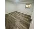 Bedroom with gray wood flooring, neutral walls, a small window, and a closet with sliding doors at 4651 S Roberts Drive, Sugar Hill, GA 30518