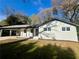 Charming white brick home featuring a convenient carport and beautifully maintained front lawn at 4651 S Roberts Drive, Sugar Hill, GA 30518