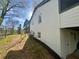 View of home's exterior, featuring a white brick facade, well-maintained lawn, and mature trees at 4651 S Roberts Drive, Sugar Hill, GA 30518