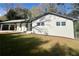 Charming home with white brick exterior, a well-manicured lawn, and a covered carport at 4651 S Roberts Drive, Sugar Hill, GA 30518