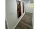 Hallway featuring gray wood flooring, neutral walls with artwork, and recessed lighting at 4651 S Roberts Drive, Sugar Hill, GA 30518