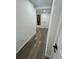 Hallway with wood floors leads to a white door, complemented by an interesting piece of modern art at 4651 S Roberts Drive, Sugar Hill, GA 30518