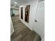 Hallway featuring gray wood flooring, neutral walls with artwork, and recessed lighting at 4651 S Roberts Drive, Sugar Hill, GA 30518