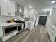 Modern kitchen with white cabinets, stainless steel appliances, and hardwood floors at 4651 S Roberts Drive, Sugar Hill, GA 30518