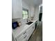 Kitchen showcasing white cabinets, stone countertops, stainless steel sink, and modern black faucet at 4651 S Roberts Drive, Sugar Hill, GA 30518