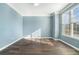 Bright bedroom featuring a large window, light blue walls, and hardwood floors at 508 Arbor Trl, Loganville, GA 30052