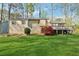 Spacious backyard with lawn, mature trees, and large wooden deck at 1870 Abercorn Way, Snellville, GA 30078