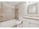 Bathroom features a tub and tiled surround, toilet, and granite vanity at 1870 Abercorn Way, Snellville, GA 30078