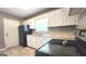 Functional kitchen featuring white cabinetry, black appliances, and durable laminate countertops at 2213 Sharon Way, Decatur, GA 30032