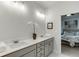 Elegant bathroom featuring double sinks, granite countertops, and doorway view to bedroom at 1260 Ainsworth Aly # 47, Sugar Hill, GA 30518