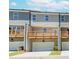 View of the townhome exteriors featuring wooden decks, gray siding and a ground level garage at 1260 Ainsworth Aly # 47, Sugar Hill, GA 30518