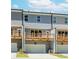 View of the townhome exteriors featuring wooden decks, gray siding and ground level garages at 1260 Ainsworth Aly # 47, Sugar Hill, GA 30518