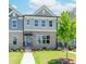 Charming brick townhome featuring gray accents, a well-manicured lawn, and inviting walkway, all under a bright blue sky at 1260 Ainsworth Aly # 47, Sugar Hill, GA 30518