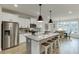 Bright kitchen features a large island with bar seating, stainless steel appliances, and modern pendant lighting at 1260 Ainsworth Aly # 47, Sugar Hill, GA 30518