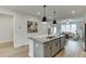 Modern kitchen features a gray island with bar seating, stainless steel appliances, and hardwood floors at 1260 Ainsworth Aly # 47, Sugar Hill, GA 30518