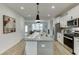 Bright kitchen with stainless appliances, white cabinets, and a large center island with seating at 1260 Ainsworth Aly # 47, Sugar Hill, GA 30518