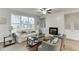 Bright living room with modern fireplace, ceiling fan, and large window at 1260 Ainsworth Aly # 47, Sugar Hill, GA 30518