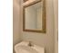 Bathroom sink with decorative gold-trimmed mirror on a neutral colored wall at 1824 Kristen Ct, Suwanee, GA 30024