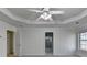 A spacious bedroom with two windows, carpet flooring, ceiling fan, and an open door to a closet at 1824 Kristen Ct, Suwanee, GA 30024