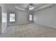 A spacious bedroom with two windows, carpet flooring, and a ceiling fan at 1824 Kristen Ct, Suwanee, GA 30024
