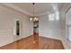 Cozy dining room featuring hardwood floors, white wall paneling, a tray ceiling, and a doorway that leads to a kitchen at 1824 Kristen Ct, Suwanee, GA 30024