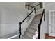 Elegant entryway staircase with black handrails, carpeted steps, and direct access to other rooms in the home at 1824 Kristen Ct, Suwanee, GA 30024