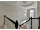 Open foyer featuring a grand chandelier and staircase with black and white railing at 1824 Kristen Ct, Suwanee, GA 30024