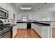 Well-lit kitchen featuring white cabinets, black countertops and modern appliances at 1824 Kristen Ct, Suwanee, GA 30024