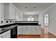 Well-lit kitchen with black countertops, white cabinets, and view of dining area and hallway at 1824 Kristen Ct, Suwanee, GA 30024