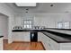 Kitchen with white cabinets and black countertops with stainless steel appliances at 1824 Kristen Ct, Suwanee, GA 30024