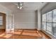Sunlit living room with hardwood floors, white wall paneling, a ceiling fan, and a doorway that leads to another room at 1824 Kristen Ct, Suwanee, GA 30024