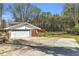 Exterior view of attached garage and driveway of home with lush surrounding greenery at 4444 Casco Nw Ln, Lilburn, GA 30047