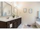 Modern bathroom featuring double sinks, a spacious vanity, a tub, and tasteful decorative accents at 5761 Sawgrass Cir, Lithonia, GA 30038