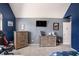Spacious bedroom featuring two dressers, television, gaming console, blue accent wall and neutral carpet at 5761 Sawgrass Cir, Lithonia, GA 30038