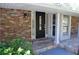 Charming brick home featuring a front door with decorative glass panels and manicured landscaping at 2520 Robin Hood Ne Pl, Marietta, GA 30068