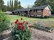 Two-story brick home with charming garden featuring red flowers and a well-manicured lawn at 2520 Robin Hood Ne Pl, Marietta, GA 30068