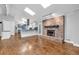 Spacious living room with hardwood floors, a brick fireplace, and an open layout leading to the modern kitchen at 2520 Robin Hood Ne Pl, Marietta, GA 30068
