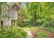 Picturesque backyard with a stone path, mature trees, and a glimpse of the home's exterior with white railings at 978 Moores Club Ne, Atlanta, GA 30319