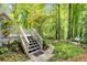 Serene backyard featuring a deck with stairs, lush landscaping, a stone pathway, and mature trees at 978 Moores Club Ne, Atlanta, GA 30319