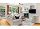 Bright living room with hardwood floors, fireplace, built-in shelves, and large windows overlooking the backyard at 978 Moores Club Ne, Atlanta, GA 30319