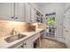 Functional mudroom with a sink, cabinets, and a door leading to the backyard, perfect for busy lifestyles at 978 Moores Club Ne, Atlanta, GA 30319