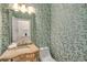 Stylish powder room featuring unique wallpaper, a decorative mirror, and a patterned vanity for added charm at 978 Moores Club Ne, Atlanta, GA 30319