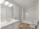 Bright bathroom featuring a single sink vanity, toilet, and a bathtub with shower at 31 Fox Creek Ct, Dallas, GA 30157