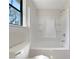 Bright bathroom with a large window, white bathtub with shower, and a toilet at 31 Fox Creek Ct, Dallas, GA 30157