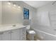 Bright bathroom with a white single sink vanity, window, and a shower over tub combination at 31 Fox Creek Ct, Dallas, GA 30157
