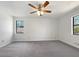 Spacious bedroom filled with natural light, ceiling fan, and plush gray carpet at 31 Fox Creek Ct, Dallas, GA 30157