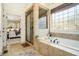 Luxurious soaking tub with a separate glass shower and decorative privacy window at 3227 Aviary Nw Ct, Acworth, GA 30101