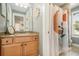 Bathroom featuring a wood vanity, decorative mirror, patterned shower curtain, and stone tiled shower at 3227 Aviary Nw Ct, Acworth, GA 30101